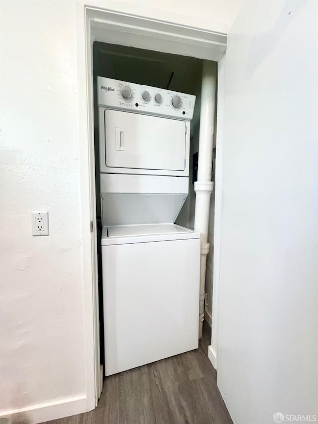 clothes washing area featuring stacked washer / dryer and hardwood / wood-style flooring