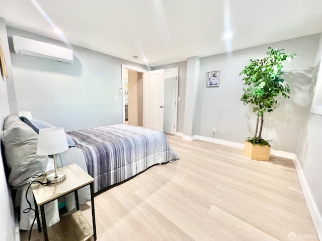 bedroom with light hardwood / wood-style floors and a wall mounted air conditioner