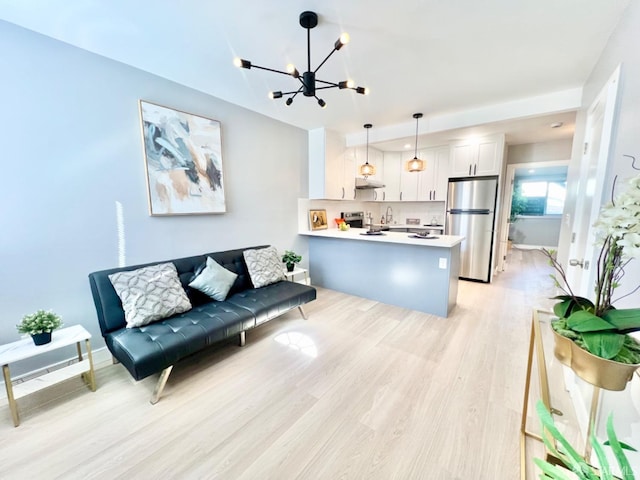 living room featuring light hardwood / wood-style floors and a notable chandelier