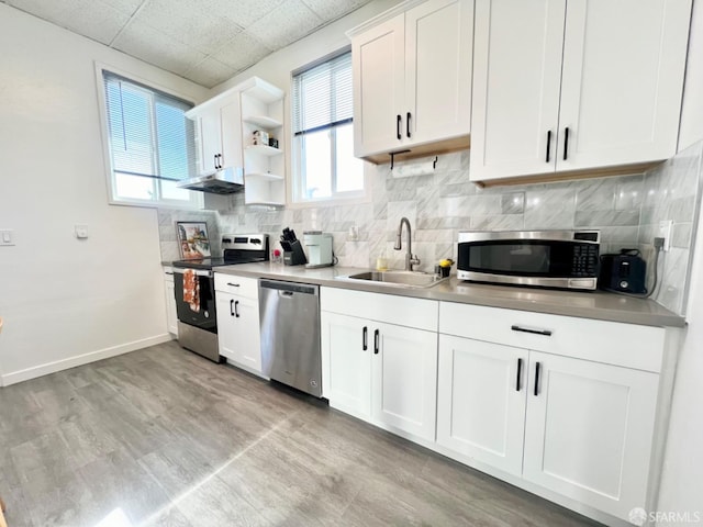 kitchen featuring white cabinetry, stainless steel appliances, sink, and light wood-type flooring