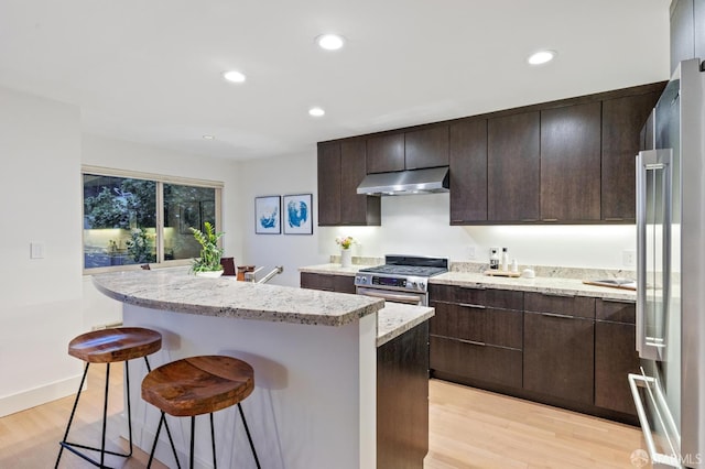 75 Roosevelt Way Unit 1, San Francisco, CA 94114 - kitchen with stainless steel appliances, under cabinet range hood, a center island, a kitchen breakfast bar, and light wood-type flooring