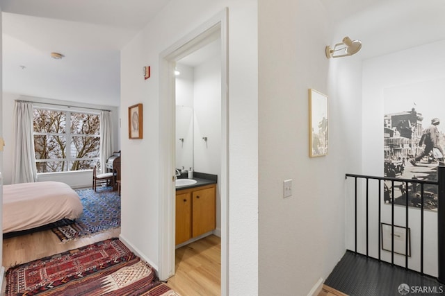 hallway with light hardwood / wood-style floors and sink