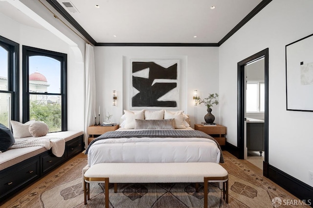 bedroom with visible vents, multiple windows, light wood-style flooring, and crown molding