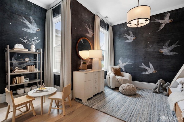 living area featuring an accent wall, wood finished floors, visible vents, and ornamental molding