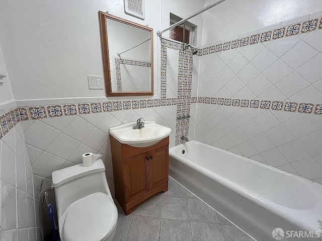 bathroom with toilet, tile walls, vanity, shower / bathing tub combination, and tile patterned floors