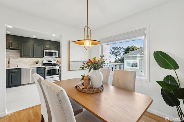 dining room with recessed lighting, baseboards, and light wood-style floors