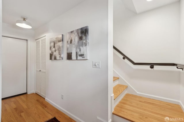 hall with stairway, baseboards, and wood finished floors