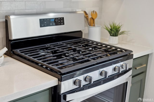 details with gas range, light countertops, and backsplash