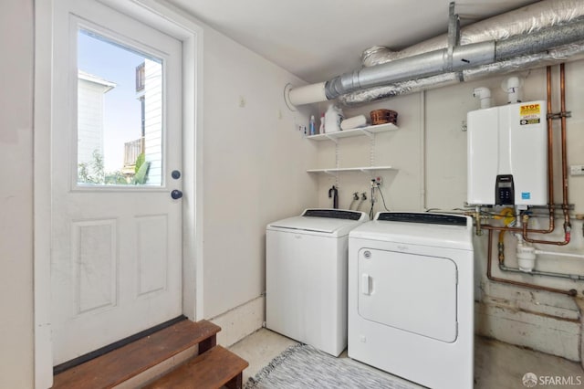 laundry area with laundry area, water heater, and washing machine and clothes dryer