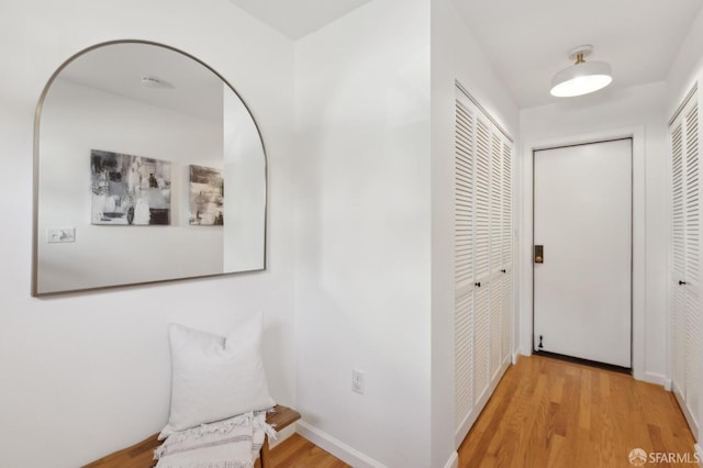 hall featuring baseboards and light wood-type flooring