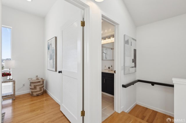 hallway with light wood-type flooring and baseboards