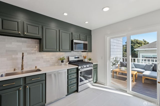 kitchen featuring recessed lighting, a sink, light countertops, appliances with stainless steel finishes, and backsplash