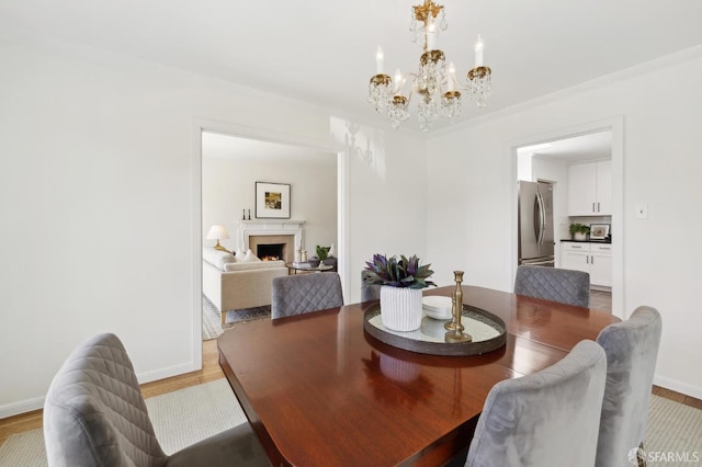 1944 15th Ave, San Francisco, CA 94116 - dining room with a chandelier, light wood-style flooring, baseboards, and a warm lit fireplace