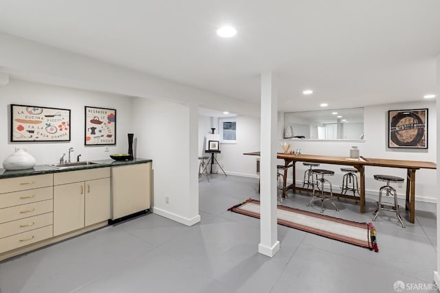 bar with sink, dishwashing machine, and cream cabinetry