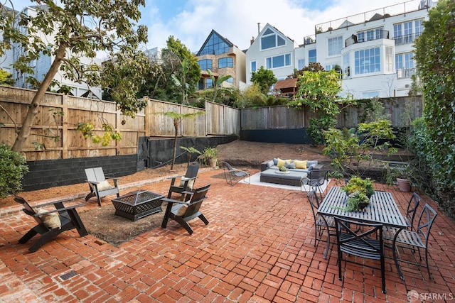 view of patio with an outdoor living space with a fire pit