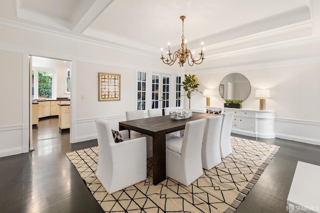 dining room with dark hardwood / wood-style flooring, ornamental molding, a tray ceiling, and a chandelier