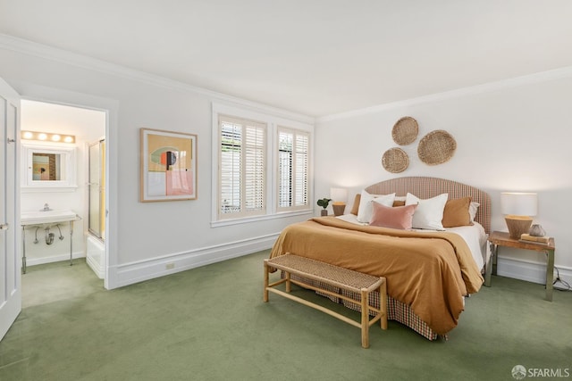 bedroom featuring ensuite bath, ornamental molding, and carpet