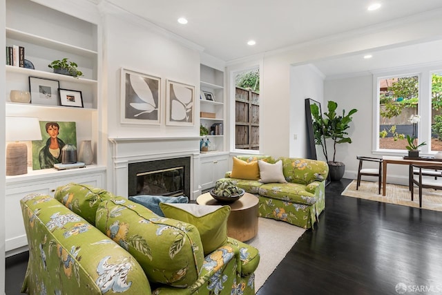 living room with crown molding, dark hardwood / wood-style floors, and built in shelves