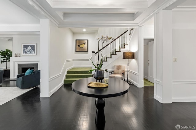 entryway with ornamental molding and dark hardwood / wood-style floors