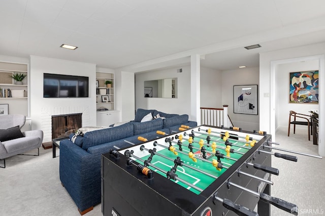 game room featuring built in features, a fireplace, and carpet