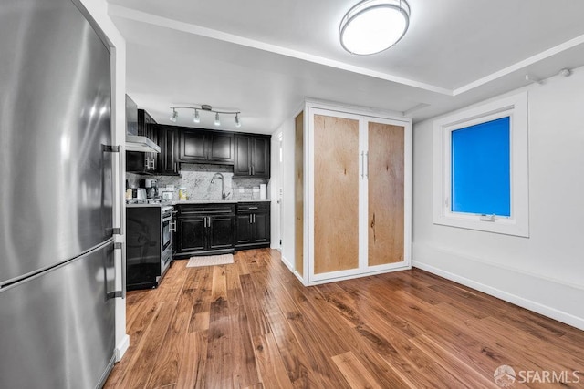 3014 Pine St Unit A, San Francisco, CA 94115 - kitchen featuring appliances with stainless steel finishes, dark cabinetry, light wood-type flooring, light countertops, and tasteful backsplash