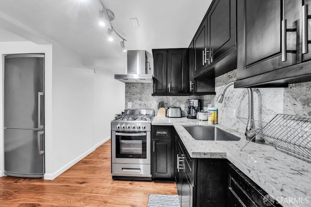 3014 Pine St Unit A, San Francisco, CA 94115 - kitchen featuring dark cabinets, wall chimney exhaust hood, appliances with stainless steel finishes, and a sink