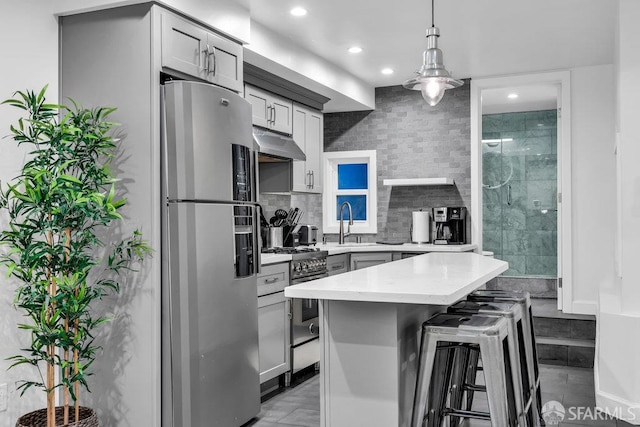 3014 Pine St Unit A, San Francisco, CA 94115 - kitchen featuring appliances with stainless steel finishes, under cabinet range hood, recessed lighting, a kitchen breakfast bar, and pendant lighting
