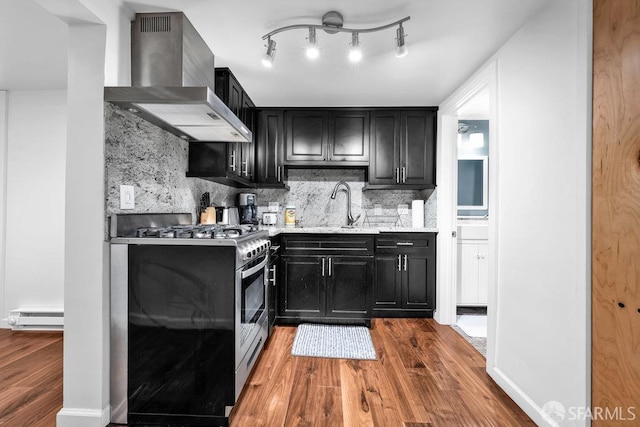 3014 Pine St Unit A, San Francisco, CA 94115 - kitchen with wall chimney range hood, dark cabinets, stainless steel gas range, wood finished floors, and baseboard heating