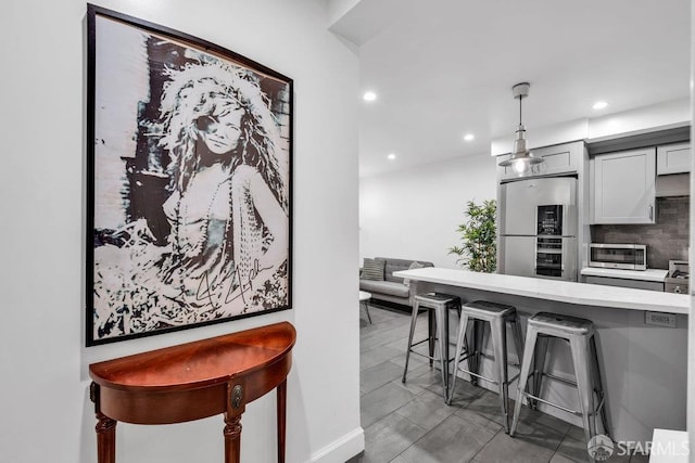 3014 Pine St Unit A, San Francisco, CA 94115 - kitchen with fridge, stainless steel microwave, a breakfast bar area, recessed lighting, and pendant lighting
