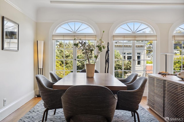 dining area with baseboards and light wood-style flooring
