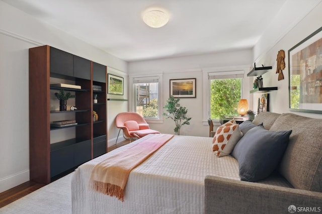 bedroom with wood finished floors and baseboards