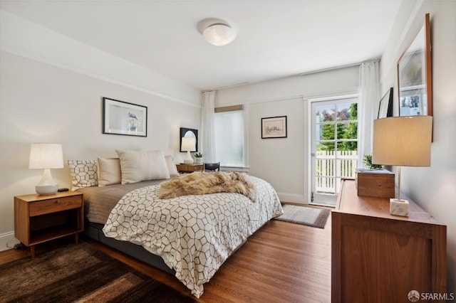 bedroom featuring access to outside, dark wood-type flooring, and baseboards