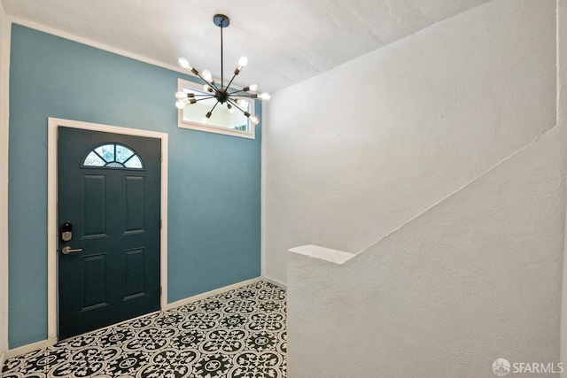 foyer featuring a chandelier and baseboards