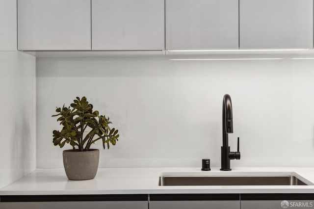 room details featuring white cabinets and sink