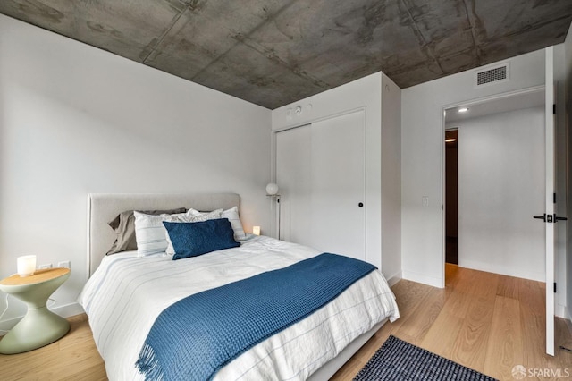 bedroom with wood-type flooring and a closet