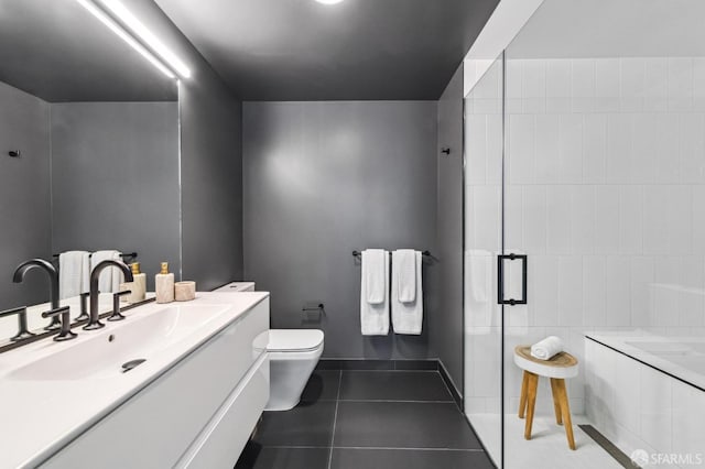 bathroom with tile patterned floors, vanity, tile walls, and toilet