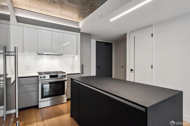 kitchen with white cabinetry, stainless steel gas stove, range hood, and light wood-type flooring