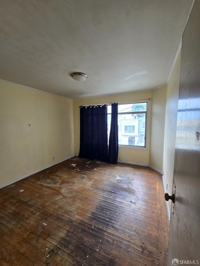 unfurnished room with baseboards and hardwood / wood-style floors