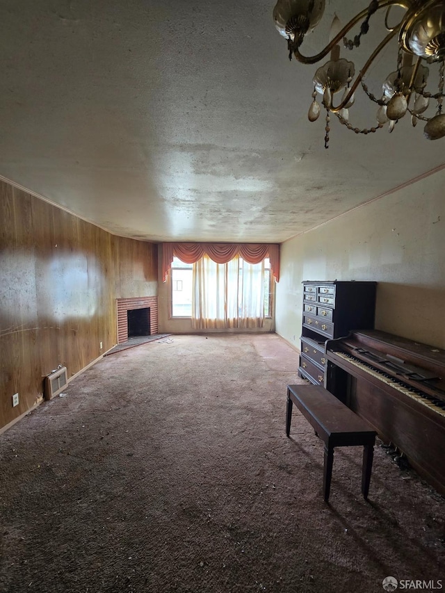living room featuring a fireplace, carpet flooring, wood walls, and a textured ceiling