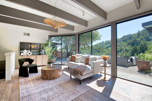 sunroom featuring beam ceiling