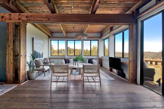 sunroom / solarium with a healthy amount of sunlight, beamed ceiling, wooden ceiling, and an inviting chandelier