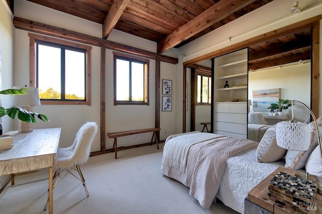 bedroom featuring beamed ceiling, wood ceiling, and light carpet