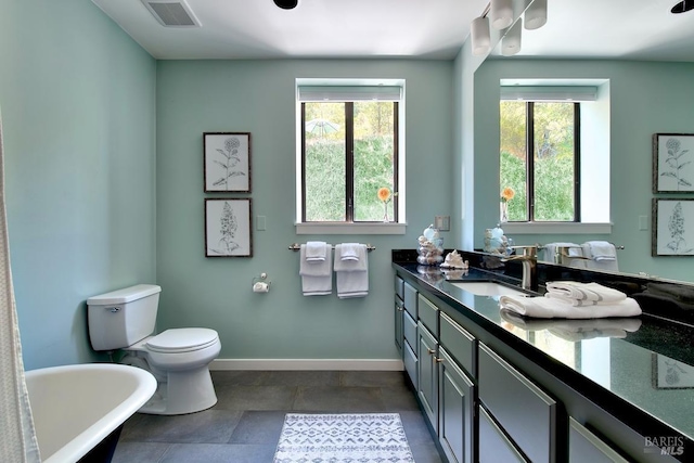 bathroom featuring a tub, vanity, and toilet