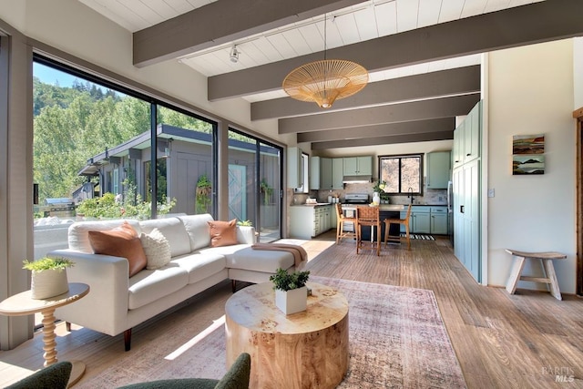 sunroom featuring beam ceiling