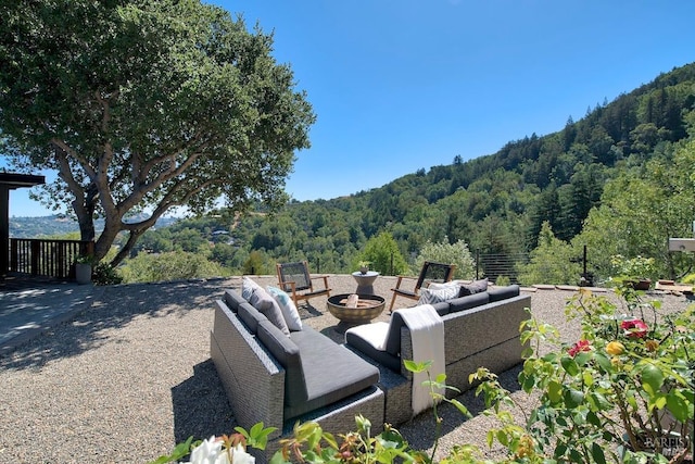 exterior space featuring a mountain view and an outdoor living space with a fire pit