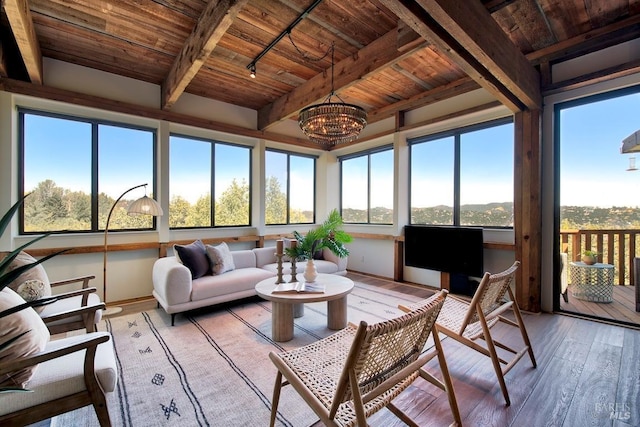 sunroom / solarium with beamed ceiling, rail lighting, wooden ceiling, and a notable chandelier