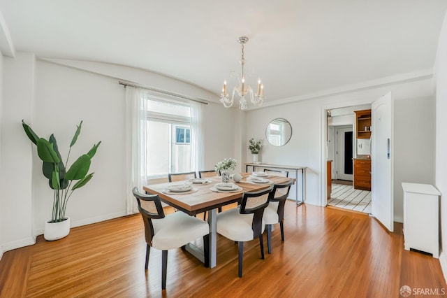 dining area featuring light hardwood / wood-style flooring and a chandelier