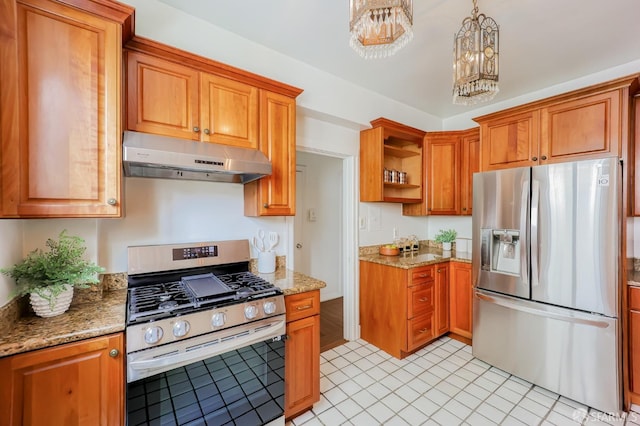 kitchen with stone countertops, appliances with stainless steel finishes, a notable chandelier, and decorative light fixtures