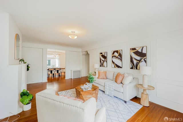 living room with an inviting chandelier and light wood-type flooring