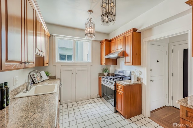 kitchen with hanging light fixtures, sink, a notable chandelier, stainless steel range with gas stovetop, and light hardwood / wood-style floors